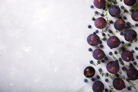 Figs and Blueberries and fragrant thyme on a light background. Autumn Berry. Food. Vegetarian. Top...