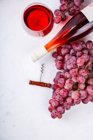 Wine Pink and Grape bunch. Alcoholic drink in a glass glass on a light background.Copy space for Text. Top View. selective focus.の写真素材