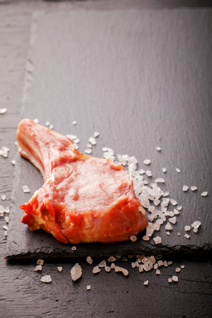 Meat Raw Fresh Mutton on the bone on a slate board  black background Copy space for Text の写真素材