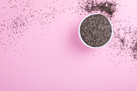 Seeds of Chia on the pink  background.Trendy Bright Colors. Concept. Minimalism. Healthy Food. Vegetarian. Diet Nutrition. Top View. Flat Lay. Copy space for Text.の写真素材