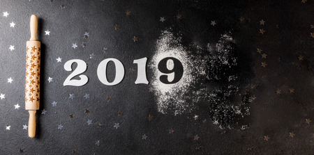 Rolling pin with a pattern in the form of stars on a black board. Baking Background .Preparation for cooking Food. Festive Christmas 2019 Concept. Copy space for Text.の写真素材