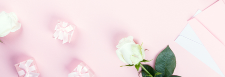 Valentine's Day composition. Gift box, white rose flowers, envelope on pastel pink background. Mother's day, Women's Day Holiday concept. Flat lay, top view,Banner, copy spaceの写真素材