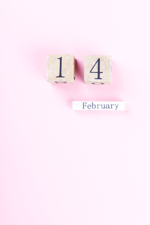 Wooden block calendar  of February 14  on a pink background. Valentine's Day, is celebrated every year.Holiday concept.Day of Love.Flat lay, top view, copy spaceの写真素材