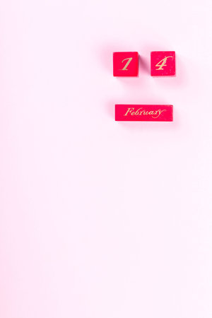 Wooden block calendar  of February 14  on a pink background. Valentine's Day, is celebrated every...