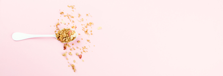 Granola Cereal bar with Strawberrie in a white spoon on a pink background..Breakfast. Healthy Food sweet dessert snack. Diet Nutrition Concept.Vegetarian food. Flat Lay.Top View. Copy spaceの写真素材