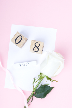 Wooden block calendar International of March 8 with white rose on a pink background. Womens Day, is celebrated every year.Holiday concept.Flat lay, top view, copy spaceの写真素材