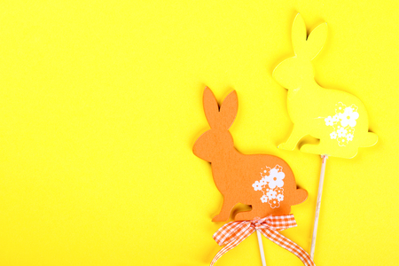 Easter background.Rabbits colored decorative wooden on yellow paper. Happy Festive concept.Top View. Flat Lay.Copy space for Textの写真素材