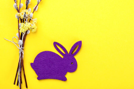 Easter background. Bouquet of Willows and  rabbit on a yellow paper.Happy Festive concept.Top View....
