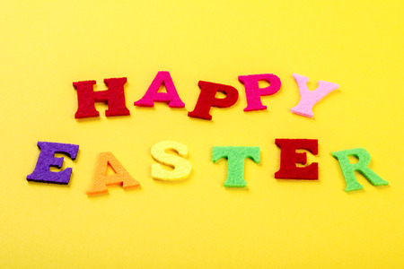 Easter concept. Inscription in colored letters Happy Easter on a yellow background.Top View. Flat Lay.Copy space for Textの写真素材