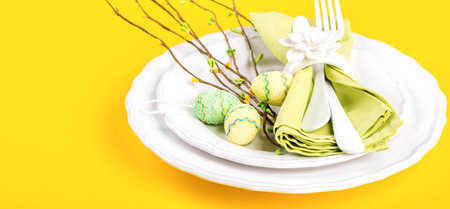 Easter table setting  on a bright yellow background. Holiday decoration.Happy Easter concept.Copy...
