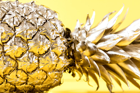 Creative layout made gold pineapple on brightly yellow background.Minimal style.  Tropical Food concept.Summer Idea .Copy space for Text.の写真素材