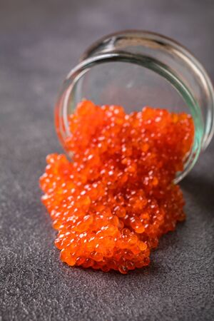 Salmon  Red Caviar in a white plate on a dark background. Healthy Food Concept. Snack.Copy space for Text.Seafood.の写真素材