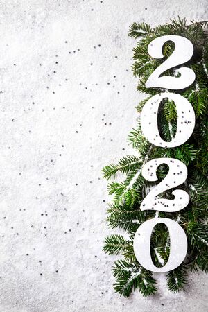 Wooden numbers concept on a snowy  with a Christmas tree branchの写真素材