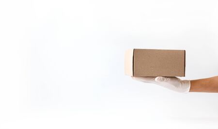 Concept of safe package delivery against Coronavirus 2019-nCov in a pandemic. Mail courier in medical gloves. Protection against the virus.Copy space .の写真素材