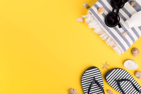 Beach accessories on yellow background. Flip flops,Sun Glasses, towel.Summer vacation concept.Travel mood to the sea.Flat lay.

の写真素材
