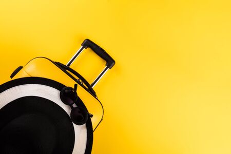 Yellow suitcase with traveler accessories on yellow background.Travel concept. Summer Time holiday.Holiday Adventure Trip.Banner.Flat layの写真素材