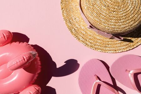 Beach accessories on pink background. Flip flops, hat and sunglasses.Summer vacation. Creative concept.Travel mood to the sea.Flat layの写真素材