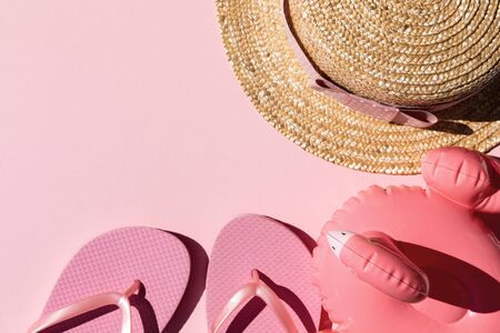 Beach accessories on pink background. Flip flops, hat and sunglasses.Summer vacation. Creative concept.Travel mood to the sea.Flat layの写真素材
