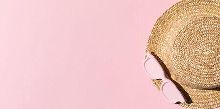 Beach accessories on pink background. Hat and sunglasses.Summer vacation. Creative concept.Travel mood to the sea.Flat lay.Bannerの写真素材