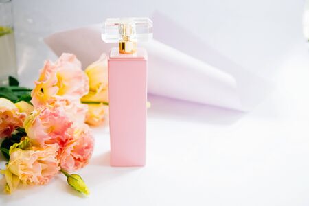 Female perfume and gentle flowers on light backgroundの写真素材