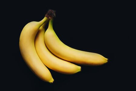 Bunch of ripe bananas on black background with copy spaceの写真素材