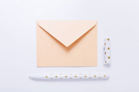 Beige envelope and pen on white backgroundの写真素材