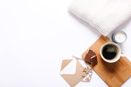 Cup of coffee, white sweater, postcard and candle on white backgroundの写真素材