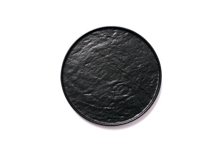 Black textured round plate isolated on whiteの写真素材