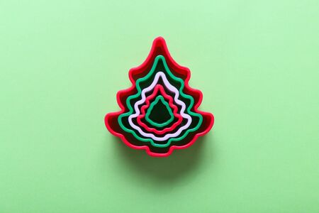 Christmas tree shape gingerbread cookie cutters on green backgroundの写真素材