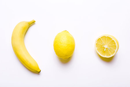 Banana and lemons in row on white backgroundの写真素材