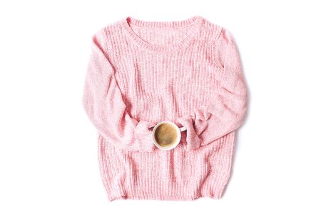 Pink knitted sweater with cup of coffee isolated on whiteの写真素材