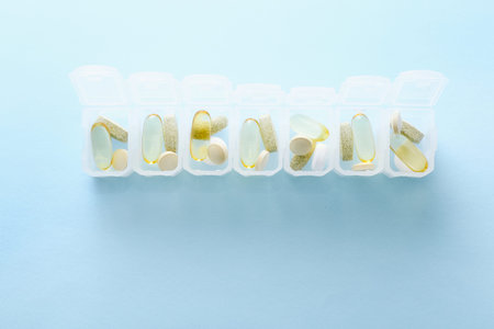 Open daily pill box on blue background.