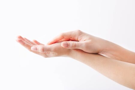 Beautiful womans hands on the white wall backgroundの写真素材