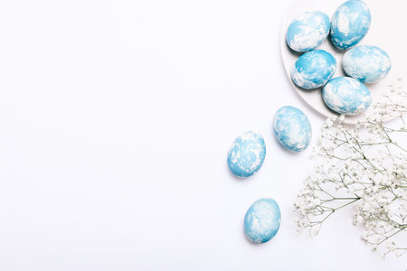 Stylish eggs with ombre blue marble stone effect on white background
