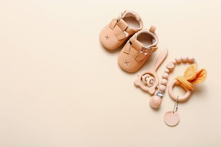 Set of baby shoes, toys and accessories on beige background. Fashion newborn stuff. Flat lay, top viewの写真素材