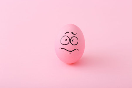 Funny pink eggs with face feeling on colorful background