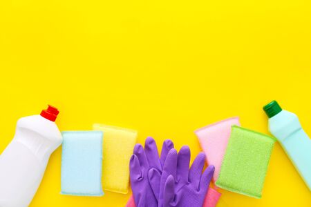 Colorful cleaning set for different surfaces in kitchen on yellow background. Top view, flat layの写真素材