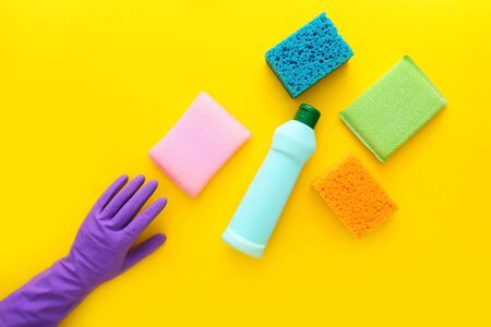 Colorful cleaning set for different surfaces in kitchen on yellow background. Top view, flat layの写真素材