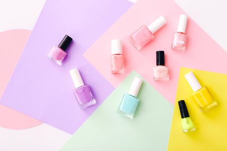 Group of nail polishes of different colors on colorful background. Top viewの写真素材