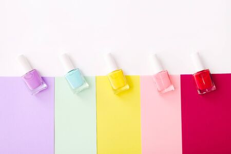Group of nail polishes of different colors on colorful background. Top viewの写真素材
