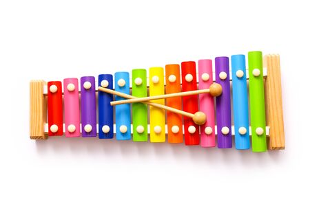 Rainbow colored wooden toy xylophone with two sticks on white background.の写真素材