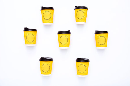Yellow cups of coffee on white desk . Concept of social distancing,new normal,COVID-19 coronavirus...