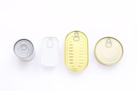 Top view of tin cans with food on white background
