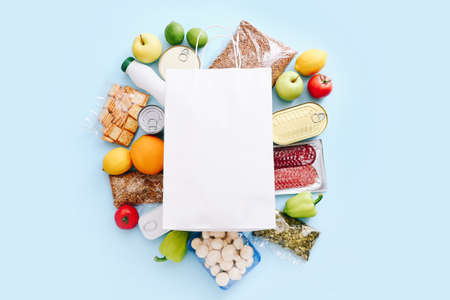 Food supplies for the period of quarantine on blue background. Set of grocery items from canned food, vegetables, cereal. Food delivery concept. Donation concept. Top view.の写真素材