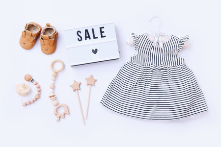Top view fashion trendy look of baby girl clothes and toy stuff. Baby fashion concept