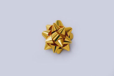 Gold bow sparkling holiday gift on a gray background. Template for greeting cardの写真素材