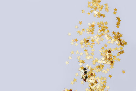 Holiday background with little golden stars on gray background. Template for greeting card, text...