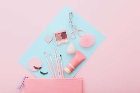 Makeup tools and accessories on blue and pink background. Beauty concept. Flat lay composition, top viewの写真素材