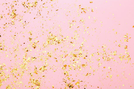 Golden confetti on the pink background. Holiday background, top viewの写真素材