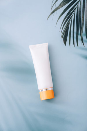 Skincare cosmetic lotion cream. Mockup bottle packaging product on blue background with palm shadows...
